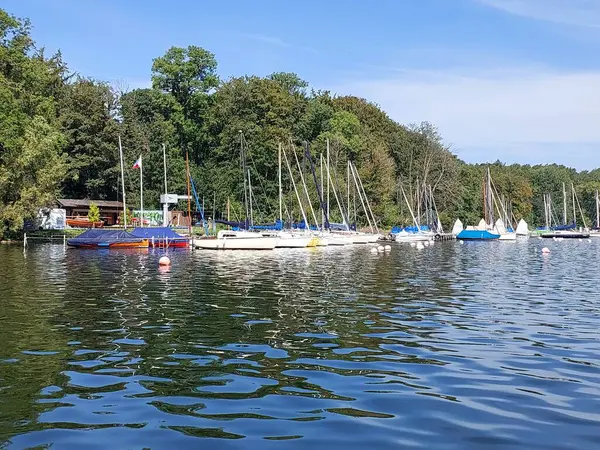 Güneşli bir günde, Almanya 'nın Pln şehrinde demirli kar beyazı yatları olan bir göl kıyısı.