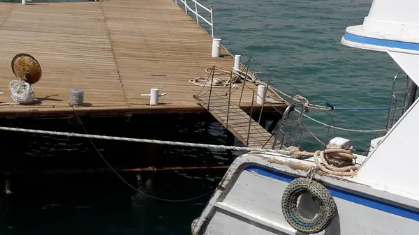 Güneş ışığında güneşlenen zarif turist yatı Mısır 'daki sakin Kızıldeniz kıyısına demirlemiş..