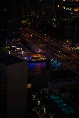 Dubai Marina 'nın gökdelenli gökdeleni, canlı ışıklar ve kıyı şeridi manzarası..