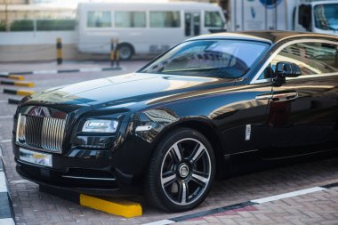 Şatafatlı siyah coupe şehir merkezinde park halinde, ikonik ızgarasını, şık tasarımını ve birinci sınıf zarafetini sergiliyor..