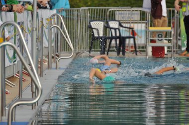 Almanya 'daki triatlon yarışması sırasında havuzda yüzen sporcular.