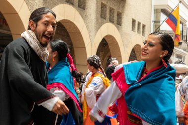 Cuenca, Ecuador - February 26, 2022: Carnival parade in Cuenca. Folk dancers at historic center of Cuenca city. Foam is sprayed on everyone.