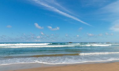 Güneşli bir günde mavi gökyüzü ile güzel tropik plaj ve okyanus manzarası.