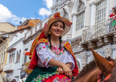 Cuenca, Ekvador - 24 Aralık 2022: Cuenca 'da Pase del Nio Viajero (Gezgin Çocuk) Noel alayı. UNESCO kültür mirası. Geleneksel Noel kıyafetleri içinde güzel bir kadın ata biniyor.