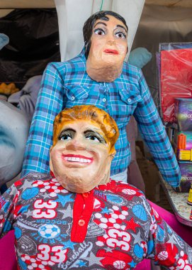 Cuenca, Ekvador - 29 Aralık 2022: Komik, komik, komedi veya siyasi maskeler takan bez bebekler veya mankenler, Monigotes 'un yeni yıl arifesini kutlamak için yakacağı bir sokak pazarında satılığa çıkarıldı.