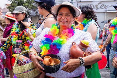 Cuenca, Ekvador - 18 Şubat 2023 Cuenca 'daki Karnaval sırasında geçit töreni. Törende seramik yapan bir kadın seyircilere gülümsüyor..