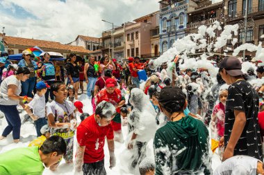 Cuenca, Ekvador - 18 Şubat 2023 Cuenca 'da yıllık karnaval etkinliği. İzleyiciler ve katılımcılar eğlenirken San Francisco Plaza 'daki bir itfaiye arabasından köpük püskürtülüyor.