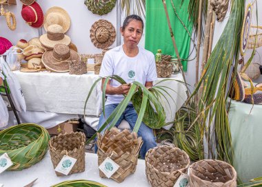 Cuenca, Ekvador - 3 Kasım 2023: Bir adam Cuenca 'daki bir sanat fuarında palmiye yapraklarından sepet yapıp satıyor. Doğal mallar..