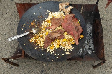 Ekvador 'un And Bölgesi' nde (Sierra) sokak yemekleri pişirmek. Önceden tütsülenmiş et, mısır ve patates. Azuay ili, Cuenca şehri.