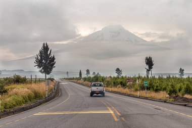 Cotopaxi, Ekvador - 19 Mart 2022: Cotopaxi Ulusal Parkı 'nda sisli bir sabah. Uzakta bulutlarla kaplı olan Cotopaxi yanardağına giden yol. Cotopaxi Eyaleti, Ekvador And Dağları