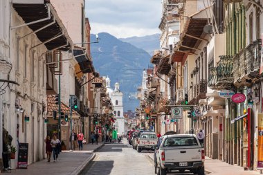 Cuenca, Ekvador - 20 Kasım 2022: Simon Bolivar Sokağı ve San Sebastian Kilisesi 'nin sonu. Bir UNESCO Dünya Mirası Alanı olan Cuenca 'nın tarihi merkezinde kentsel yaşam.