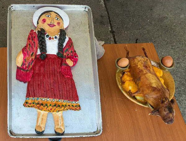 stock image Large 'Guagua de pan' bread as chola cuencana in traditional costume of Azuay province. Grilled guinea pig or cuy with Llapingachos. Traditional ecuadorian food for 'Day of the Dead'. Cuenca, Ecuador