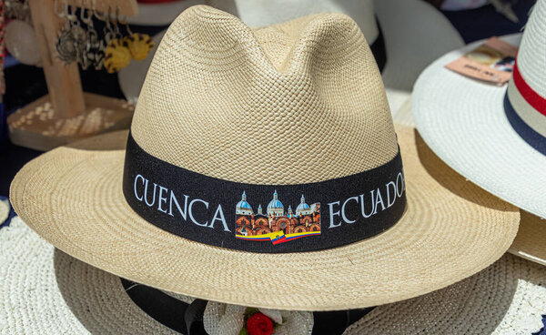 Ручной классический стиль Panama Hat или сомбреро с деревенским названием "Ecuador" и названием города "Cuenca" на традиционном открытом рынке в Cuenca. Популярный сувенир из Эквадора