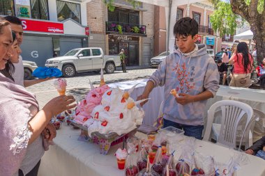 Cuenca, Ekvador - 3 Kasım 2023: Bir adam Espumilla de guayaba (guava köpüğü), yumurta beyazı ve guava ile tatlandırılmış geleneksel bir Ekvador tatlısıdır, dondurma külahlarında servis edilir. Sokak yemeği.