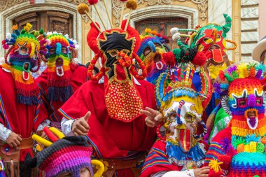 Cuenca, Ekvador - 24 Aralık 2023: Cuenca 'nın tarihi merkezinde düzenlenen yıllık Pase del Nio Viajero Noel geçit töreninde Inti Raymi karakterlerinin Diablo Huma (Şeytan) olarak adlandırdığı neşeli bir dansçı grubu