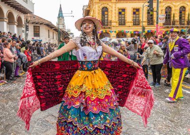 Cuenca, Ekvador - 10 Şubat 2024: Cuenca 'nın tarihi merkezinde karnaval alayı. Azuay 'ın tipik nakışlı elbisesi içinde genç bir kadın. İnsanlar geleneksel olarak birbirlerine köpük atarlar..