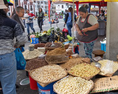 Cuenca, Ekvador - 29 Mart 2024: Kimliği belirlenemeyen kadın markette yemek pişirmek için kullanılan malzemeleri satıyor. Çeşitli tahıllar, baklagiller, sebzeler. Kutsal hafta ve Paskalya 'da yenen Ekvador yemekleri