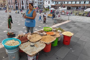 Cuenca, Ekvador - 29 Mart 2024: Kimliği belirlenemeyen kadın markette yemek pişirmek için kullanılan malzemeleri satıyor. Çeşitli tahıllar, baklagiller, sebzeler. Kutsal hafta ve Paskalya 'da yenen Ekvador yemekleri