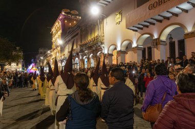 Cuenca, Ekvador - 26 Mart 2024: Ekvador 'da Kutsal Hafta kutlamaları. Cucuruchos, Cuenca 'nın tarihi merkezinin sokaklarında İsa Geçit Töreni' nde yürüyor.