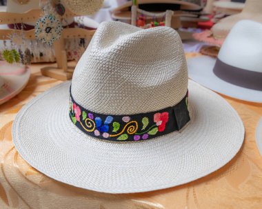 Cuenca, Ekvador - 13 Nisan 2024: Cuenca, Ekvador 'da bir markette çiçek desenli samandan yapılmış klasik bir Panama şapkası veya sombrero el yapımı.