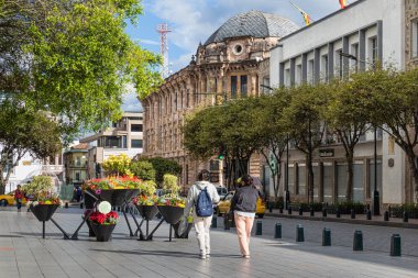 Cuenca, Ekvador - 29 Aralık 2024: Cuenca tarihi merkezi. Çiçekli kompozisyon. Padre Aguirre Caddesi 'ndeki idari ve tarihi binalar. Tanımlanamayan yayalar.