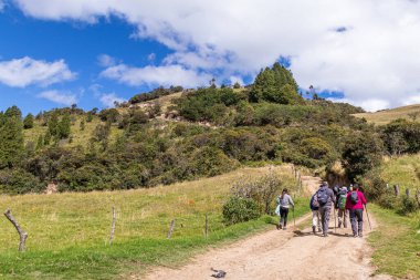 Azuay, Ekvador - 6 Temmuz 2025: Bir grup yürüyüşçü Huasipamba, Santa Isabel Canton, Azuay, Ekvador And Dağları 'ndaki Bolarrumi kaya kompleksine giden toprak yolda yürüyor