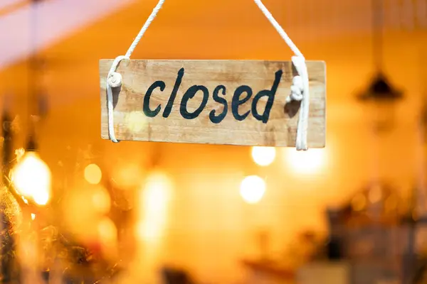 closed sign wooden board hanging on door of cafe