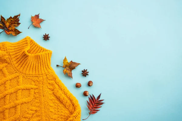 秋天平平的背景 带落叶和蓝色香料的针织橙色毛衣 — 图库照片