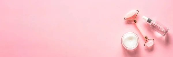 スキンケアの概念 ピンクの玉ローラー クリームと血清ボトル 長い旗の形式 — ストック写真