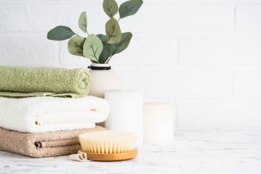 Aksesuarlı banyo. Havlu, kozmetik ve mum yığını.