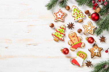 Christmas gingerbread with decorations on white wooden table. Christmas baking. Top view with copy space.
