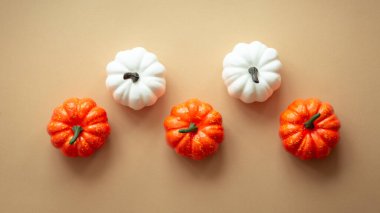 Sonbahar düz arka planda yatıyordu. Renkli düzende turuncu balkabakları. Kopya alanı olan sonbahar dekorasyonları.