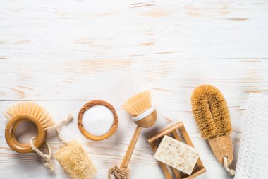 Beyaz ahşap masadaki mutfak için sıfır atık temizleme aleti. Doğal fırçalar, sabun ve havlu. Plastiksiz konsept. Yeniden kullanılabilir, sürdürülebilirlik, çevre dostu. Düz görünüm.