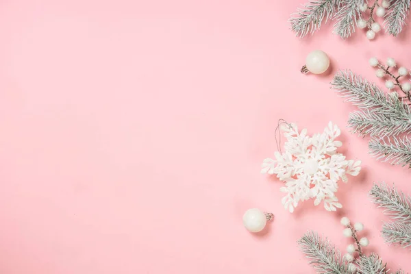 Christmas pink flat lay background. Fir tree and white christmas decorations top view with copy space.