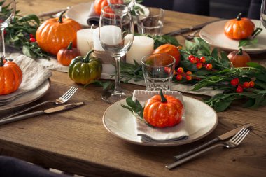 Tabak, cam, çatal bıçak ve sonbahar dekoruyla ahşap masada sonbahar masası. Şükran Günü yemeği şenlik yemeği konsepti.
