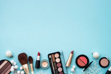 Mavi arka planda ürünler ve Noel süslemeleri var. Tatil alışverişi konsepti. Kopyalama alanı olan düz resim.