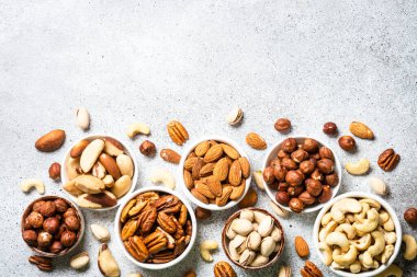 Fındık çeşitleri kaselerde. Ceviz, fındık, ceviz, badem, Brezilya fındığı ve şam fıstığı. Kopyalama alanı olan üst görünüm.