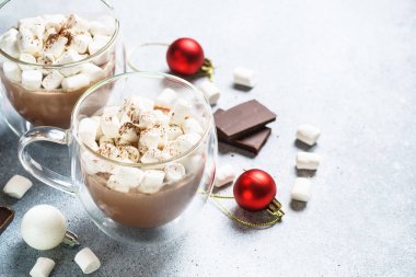 Cam bardakta kremalı sıcak çikolata ve taş masada noel süslemeleri..