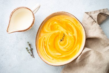 Taş masadaki el işi kasesinde kremalı balkabağı çorbası. Sağlıklı beslenme. Kopyalama alanı olan üst görünüm.