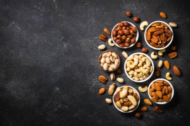 Fındıklar kaselerde. Fındık, fındık, ceviz, badem, Brezilya fındığı ve şam fıstığı. Kopyalama alanı olan üst görünüm.