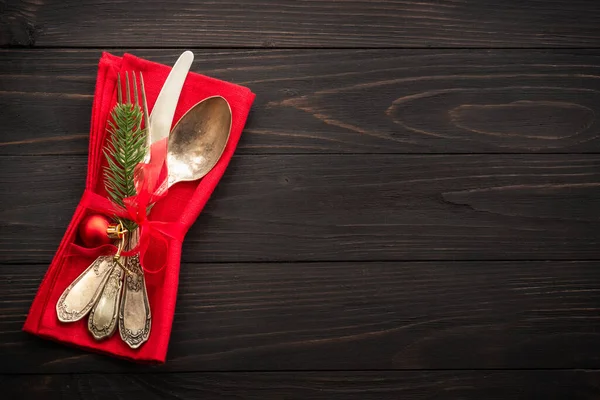 Christmas food, christmas table setting with cutlery and christmas decorations on dark wooden background. Top view.