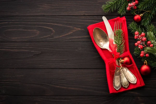 Christmas food, christmas table with cutlery and christmas decorations on dark wooden background. Top view.