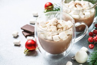 Cam bardakta kremalı sıcak çikolata ve taş masada noel süslemeleri..