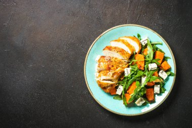 Fırında tavuk göğsü, balkabağı, mavi peynir ve roka ile sıcak salata. Dash diyeti, keto diyeti. En üst görüntü.