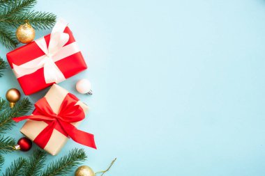 Mavi üzerine Noel süslemeleri olan bir Noel kompozisyonu. Firavun ağacı, hediye kutusu ve dekor. Kopyalama alanı olan düz..