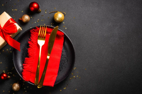 Χριστουγεννιάτικο Τραπέζι Μαύρο Πιάτο Χρυσά Μαχαιροπήρουνα Και Στολίδια Πάνω Όψη — Φωτογραφία Αρχείου