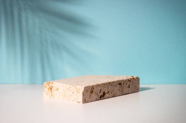Kozmetik ürünleri sunumu için taş podyum. Palmiye yaprakları gölge.