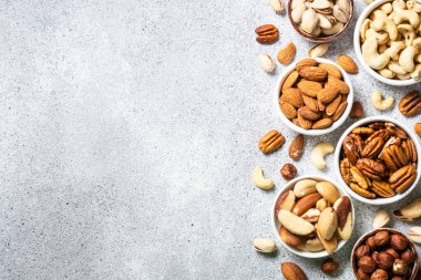 Fındık çeşitleri kaselerde. Fındık, fındık, ceviz, badem, Brezilya fındığı ve şam fıstığı. Kopyalama alanı olan üst görünüm.