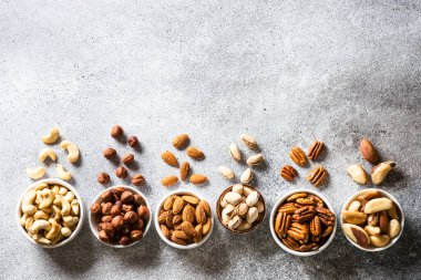 Fındık çeşitleri kaselerde. Ceviz, fındık, ceviz, badem, Brezilya fındığı ve şam fıstığı. Kopyalama alanı olan üst görünüm.