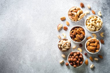 Fındık çeşitleri kaselerde. Fındık, fındık, ceviz, badem, Brezilya fındığı ve şam fıstığı. Kopyalama alanı olan üst görünüm.